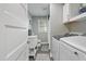 Bathroom with gray walls and flooring features a laundry area with washer and dryer at 309 S Mckay Ave, Dunn, NC 28334