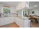 Charming kitchen with white cabinetry, granite counters, and adjacent dining area at 309 S Mckay Ave, Dunn, NC 28334