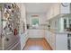 Galley kitchen features white cabinets, granite countertops, stainless steel refrigerator, and wood-look floors at 309 S Mckay Ave, Dunn, NC 28334