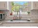 Kitchen sink features granite countertops, subway tile backsplash, and stainless steel faucet at 309 S Mckay Ave, Dunn, NC 28334