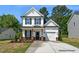 Charming two-story home with a covered porch, attached garage, and well-maintained landscaping at 325 Bluejay St, Clayton, NC 27520