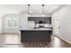Modern kitchen features gray cabinets, stainless steel appliances, and island with granite countertop at 325 Bluejay St, Clayton, NC 27520