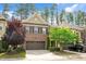 Beautiful brick townhome featuring a two-car garage, mature trees, and manicured lawn at 329 Castle Rock Ln, Cary, NC 27519