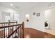Bright hallway featuring hardwood floors, white walls with decorative nooks, and an adjacent laundry room at 329 Castle Rock Ln, Cary, NC 27519