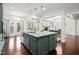 Open-concept kitchen showcasing a large island, stylish pendant lighting and access to an outdoor patio at 329 Castle Rock Ln, Cary, NC 27519