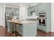 A spacious kitchen featuring a large granite island, stainless steel appliances, and stylish light-green cabinetry at 329 Castle Rock Ln, Cary, NC 27519