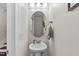 A stylish powder room with an oval mirror, pedestal sink and framed art at 329 Castle Rock Ln, Cary, NC 27519