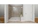 Tiled shower with a glass door, rainfall shower head, and a built-in niche for toiletries at 329 Castle Rock Ln, Cary, NC 27519