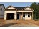 New construction featuring a covered porch and an attached garage with unfinished siding at 335 Bluejay St, Clayton, NC 27520