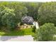 Aerial shot of a blue, two-story home nestled among mature trees, showcasing its sprawling lot and lush surroundings at 3587 Garner Terrace Way, Wake Forest, NC 27587