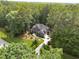 Aerial shot of a luxurious home nestled among mature trees, showcasing its well-manicured lawn and circular driveway at 3587 Garner Terrace Way, Wake Forest, NC 27587