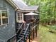 Elevated back porch includes a dining table and relaxing chairs under an umbrella at 3587 Garner Terrace Way, Wake Forest, NC 27587