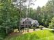 Beautiful two-story home with a stone and blue facade amidst a lush green lawn and mature trees at 3587 Garner Terrace Way, Wake Forest, NC 27587