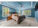 Bright main bedroom with tray ceiling, ceiling fan, carpet floors, and windows overlooking a wooded area at 3587 Garner Terrace Way, Wake Forest, NC 27587