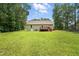 Wide view of the back of the property featuring a large manicured lawn and wooded area at 39 Blue Heron Ct, Kenly, NC 27542