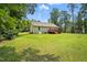 Exterior view of the back of the property featuring a manicured lawn and wooded area at 39 Blue Heron Ct, Kenly, NC 27542
