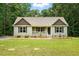 Charming single-story home with a cozy front porch and well-manicured lawn surrounded by mature trees at 39 Blue Heron Ct, Kenly, NC 27542