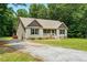 Inviting single-story home with a gravel driveway and a charming front porch, nestled among mature trees at 39 Blue Heron Ct, Kenly, NC 27542
