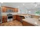 Modern kitchen with wood cabinets, granite countertops, and stainless steel appliances at 39 Blue Heron Ct, Kenly, NC 27542