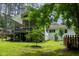 Lush backyard featuring a raised wooden deck, manicured lawn, mature trees, and tasteful landscaping at 3934 Hope Valley Rd, Durham, NC 27707