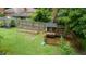 Spacious backyard featuring a chicken coop, raised garden, mature trees, and a sturdy perimeter fence at 3934 Hope Valley Rd, Durham, NC 27707