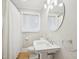 Bright bathroom featuring a pedestal sink, an oval mirror, and a shower behind a white curtain at 3934 Hope Valley Rd, Durham, NC 27707