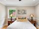 A bedroom featuring a bed, a colorful pillow, and bedside tables with unique lamps at 3934 Hope Valley Rd, Durham, NC 27707
