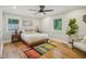 Bright bedroom with hardwood floors, a ceiling fan, a decorative rug, and a large houseplant at 3934 Hope Valley Rd, Durham, NC 27707