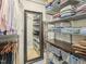 Walk-in closet with custom shelving, drawers, clothes racks, an integrated mirror, and ample storage space at 3934 Hope Valley Rd, Durham, NC 27707
