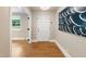 Warm, inviting foyer featuring gleaming hardwood floors and a modern art piece at 3934 Hope Valley Rd, Durham, NC 27707