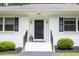 Inviting front door entrance with sleek black door, white stairs, and manicured shrubs at 3934 Hope Valley Rd, Durham, NC 27707