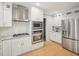 Modern kitchen with stainless steel appliances and white cabinets at 3934 Hope Valley Rd, Durham, NC 27707
