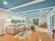 Bright living room featuring a stylish blue ceiling, neutral sectional and hardwood floors at 3934 Hope Valley Rd, Durham, NC 27707