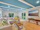 Bright living room featuring a stylish blue ceiling, neutral sectional and hardwood floors at 3934 Hope Valley Rd, Durham, NC 27707