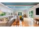 Bright living room featuring a stylish blue ceiling, neutral sectional and hardwood floors at 3934 Hope Valley Rd, Durham, NC 27707