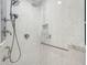 Close-up of a shower featuring marble tile, multiple shower heads, and a built-in niche at 3934 Hope Valley Rd, Durham, NC 27707