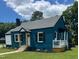 Charming blue brick home featuring a cozy front porch and well-maintained landscaping at 408 N Maple St, Graham, NC 27253
