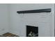 Close up of a white painted brick fireplace with black trim and wood logs at 408 N Maple St, Graham, NC 27253