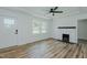 Bright living room boasts new floors, a fireplace, and a modern ceiling fan at 408 N Maple St, Graham, NC 27253