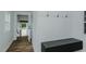 Bright mudroom features wainscoting, hooks, window, and built-in bench near entry to backyard at 408 N Maple St, Graham, NC 27253