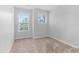 Empty bedroom with two windows providing natural light and carpeted floors at 412 Heritage Village Ln, Apex, NC 27502