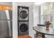 Convenient laundry area with modern, stacked washer and dryer units, next to dining nook at 412 Heritage Village Ln, Apex, NC 27502