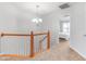 Upstairs hallway featuring carpeted floors and a staircase with an orange wooden railing at 412 Heritage Village Ln, Apex, NC 27502