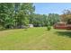 Large backyard featuring mature trees, a shed, and deck area for outdoor living at 4403 Jeffries Rd, Durham, NC 27704