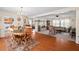 Warm dining room featuring hardwood floors, a rustic table with seating, and a transition to a carpeted living area at 4403 Jeffries Rd, Durham, NC 27704
