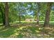 Front yard with a charming one-story house featuring trees, green grass, and natural light at 4403 Jeffries Rd, Durham, NC 27704