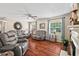 Comfortable living room with hardwood floors, cozy furniture, a ceiling fan, and natural light from the windows at 4403 Jeffries Rd, Durham, NC 27704