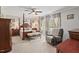 Spacious primary bedroom with a four-poster bed, comfortable chair, and neutral decor at 4403 Jeffries Rd, Durham, NC 27704