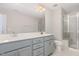A primary bathroom featuring a double vanity with light gray cabinets and glass enclosed shower at 503 Gateway Townes Blvd, Wake Forest, NC 27587