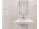 A clean bathroom with a white pedestal sink, mirror, and wall-mounted towel rack at 503 Gateway Townes Blvd, Wake Forest, NC 27587